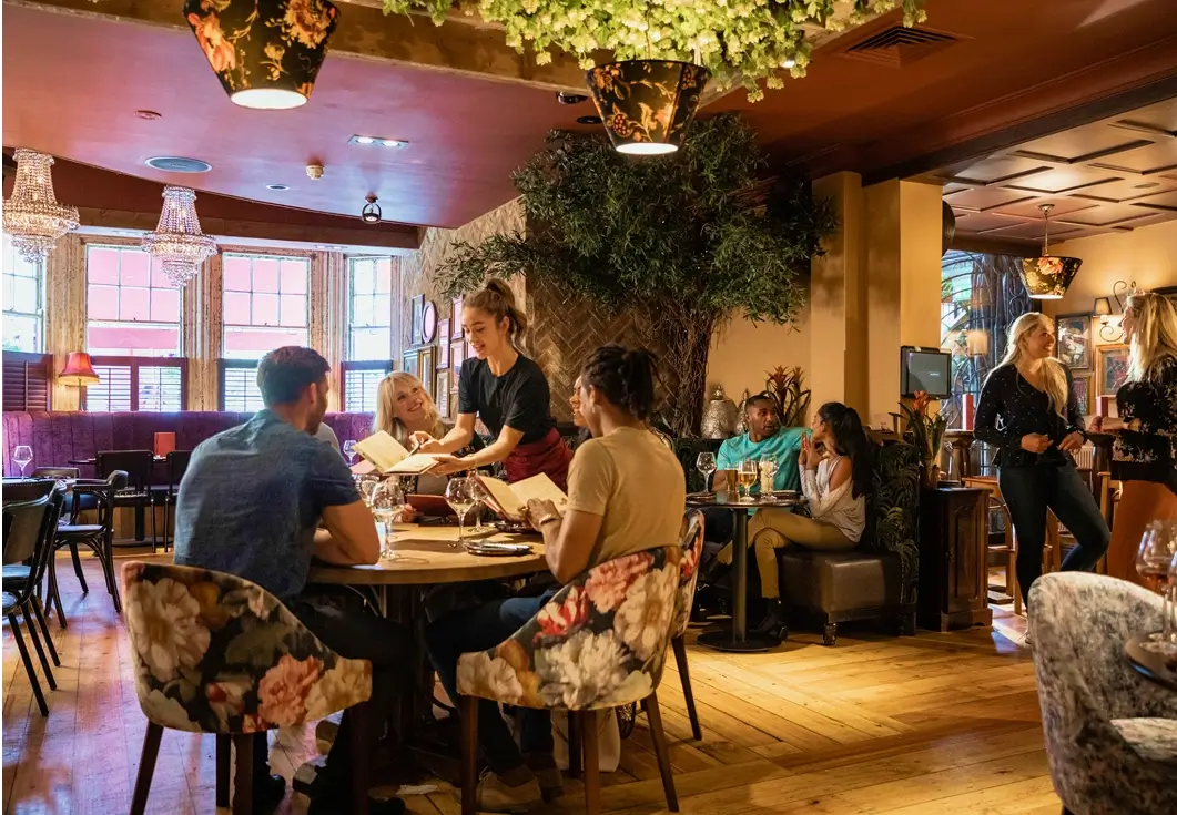 Restaurant interior with people dining and talking.